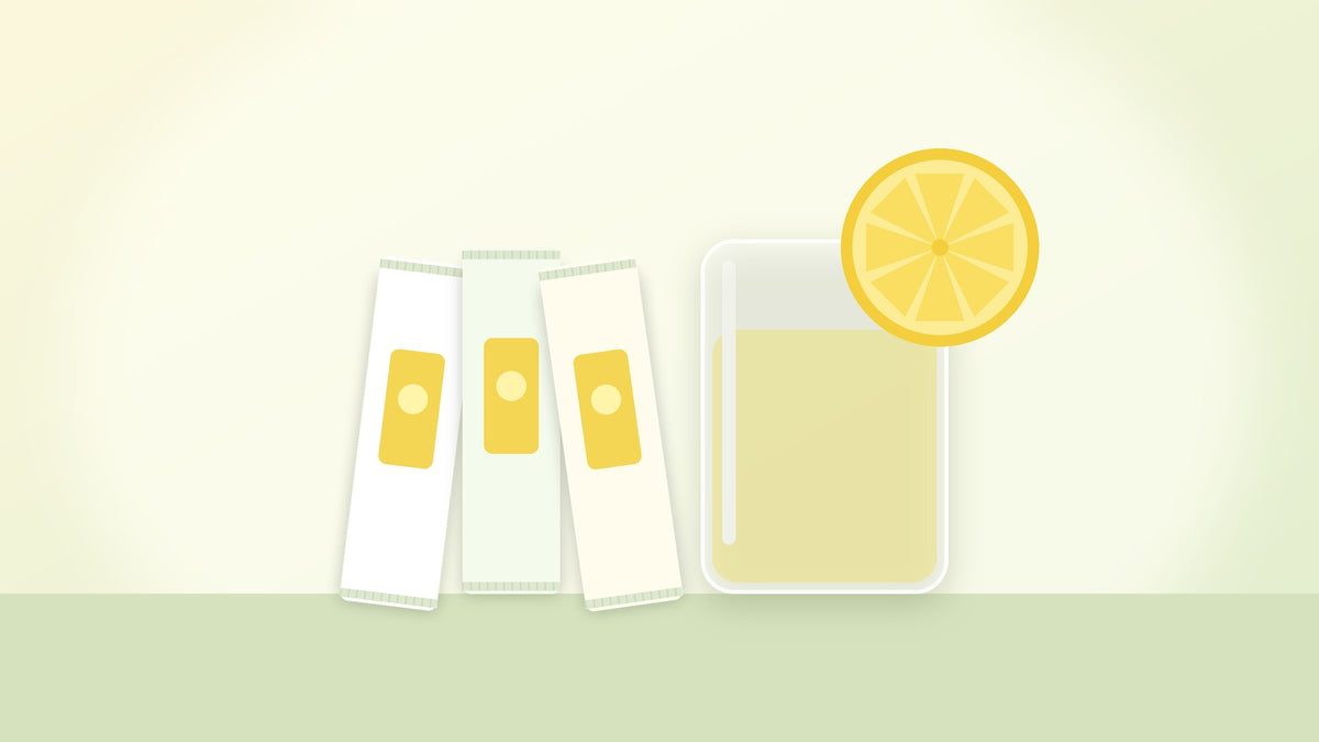 Illustration of three single-serving sachet sticks next to a glass of lemony water with a lemon slice, for the Lactis review